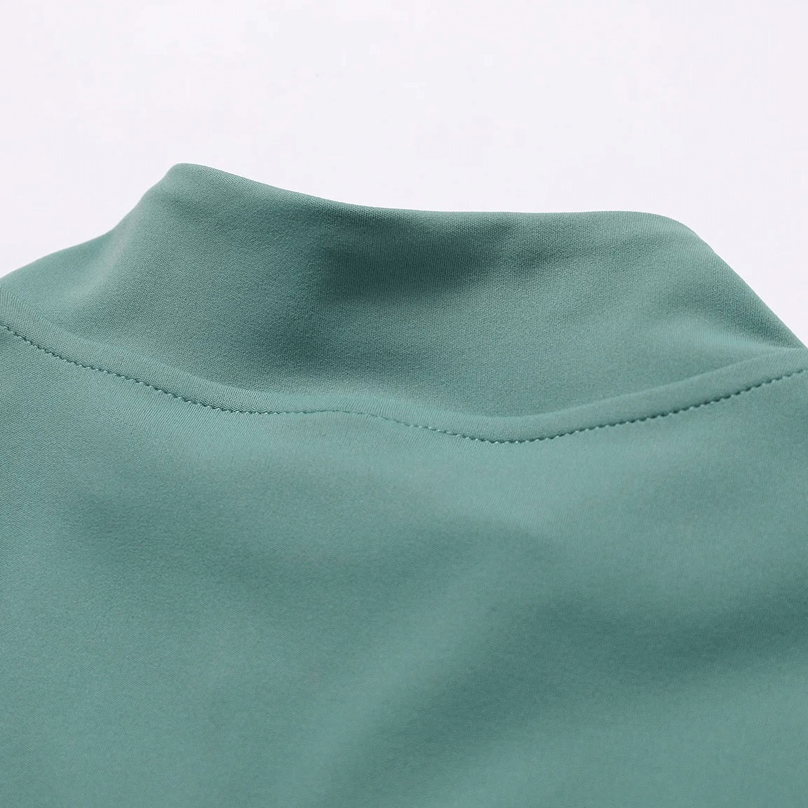 Close-up of the collar on a green women's quick-drying yoga shirt, showcasing smooth seams and breathable fabric.